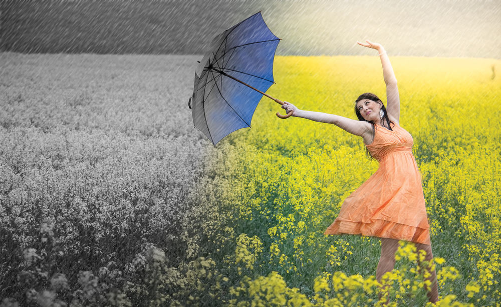 Woman dancing in a field with an umbrella