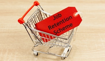 Miniature shopping trolley with a label saying job retention scheme