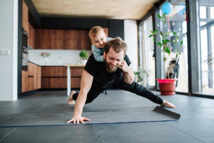 Man goes a press up with a baby on his back