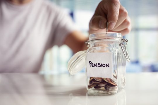 Man placing coin in pension jar