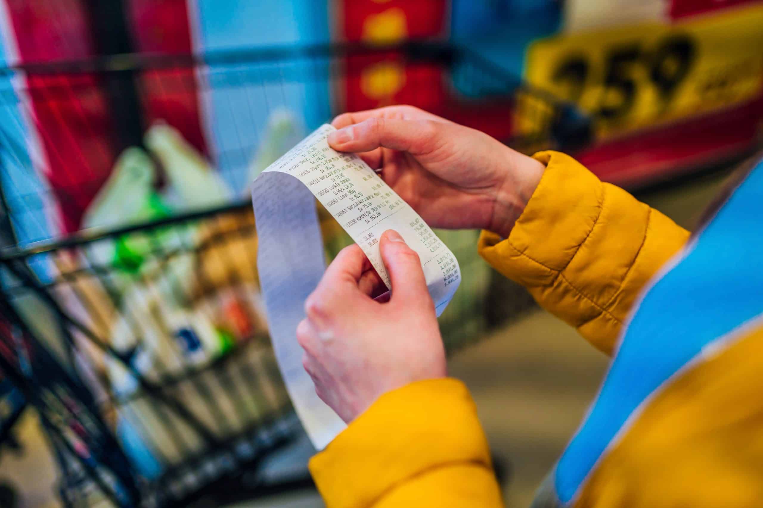 hands holding a long shopping receipt