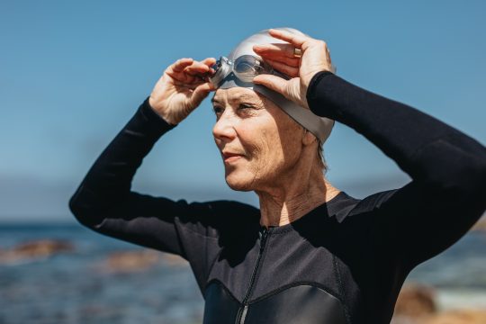 Female swimmer standing on the beach