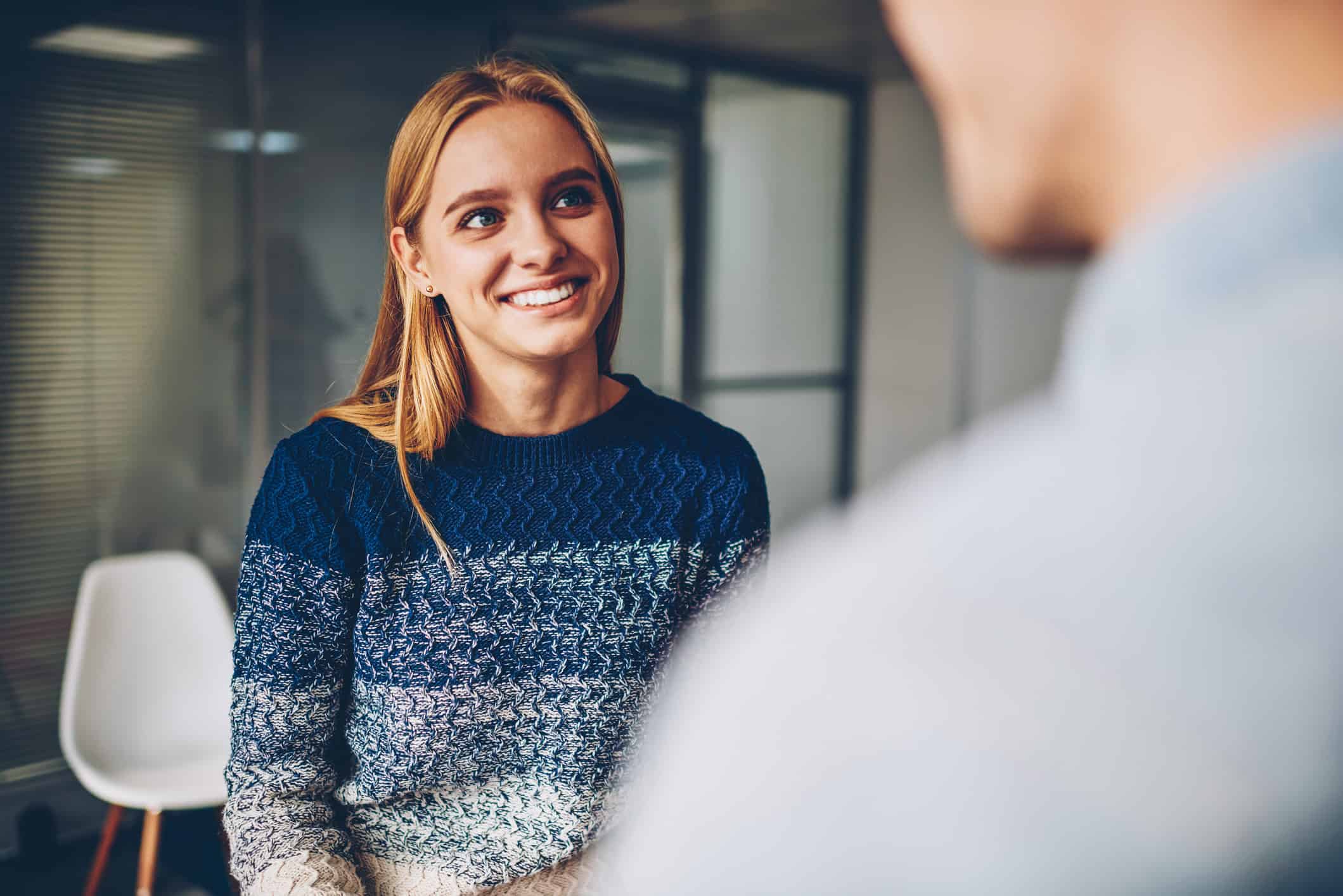 Woman smiling towards a man in an office setting