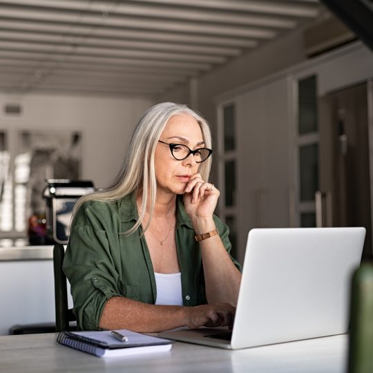 Worried senior woman using laptop