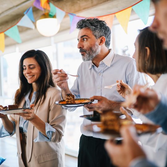 Four office colleagues pictured eating cake at a birthday party