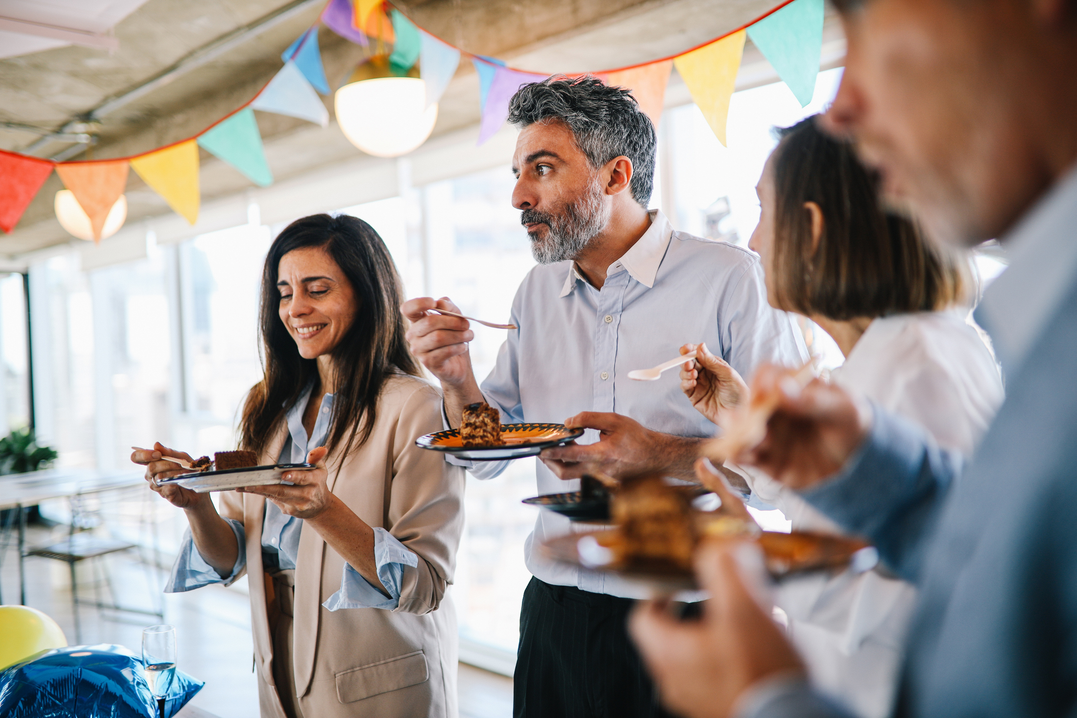 Four office colleagues pictured eating cake at a birthday party
