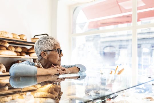 Depressed senior woman at work feeling sad