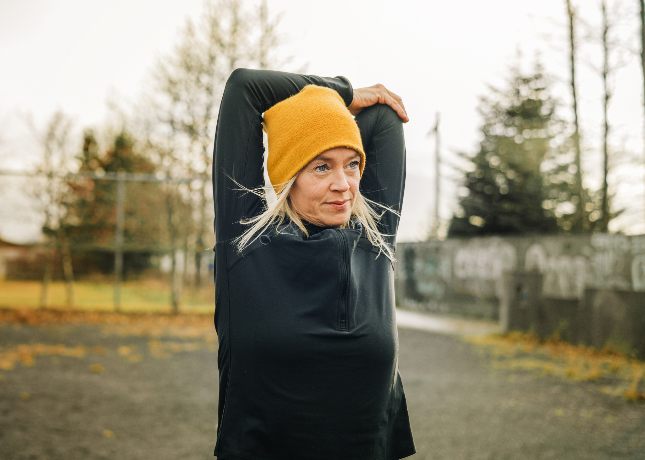 Mature woman stretching arms in the city park