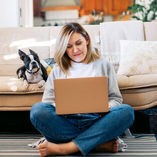 Young woman working from home with a boston terrier dog