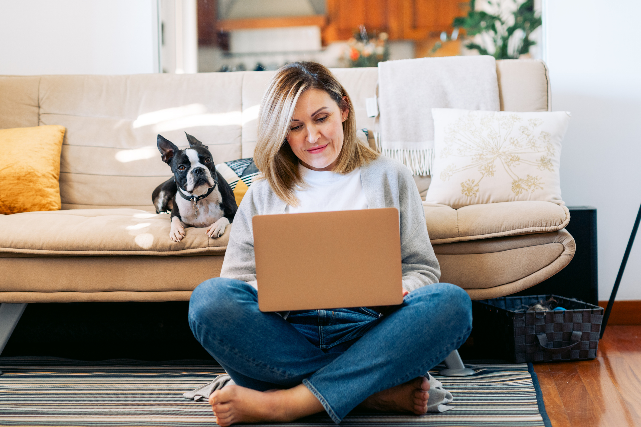 Young woman working from home with a boston terrier dog