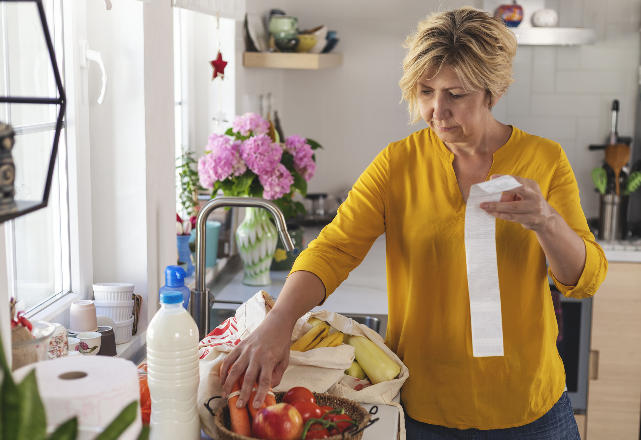 Shoot of woman going through her receipts at home after buying groceries