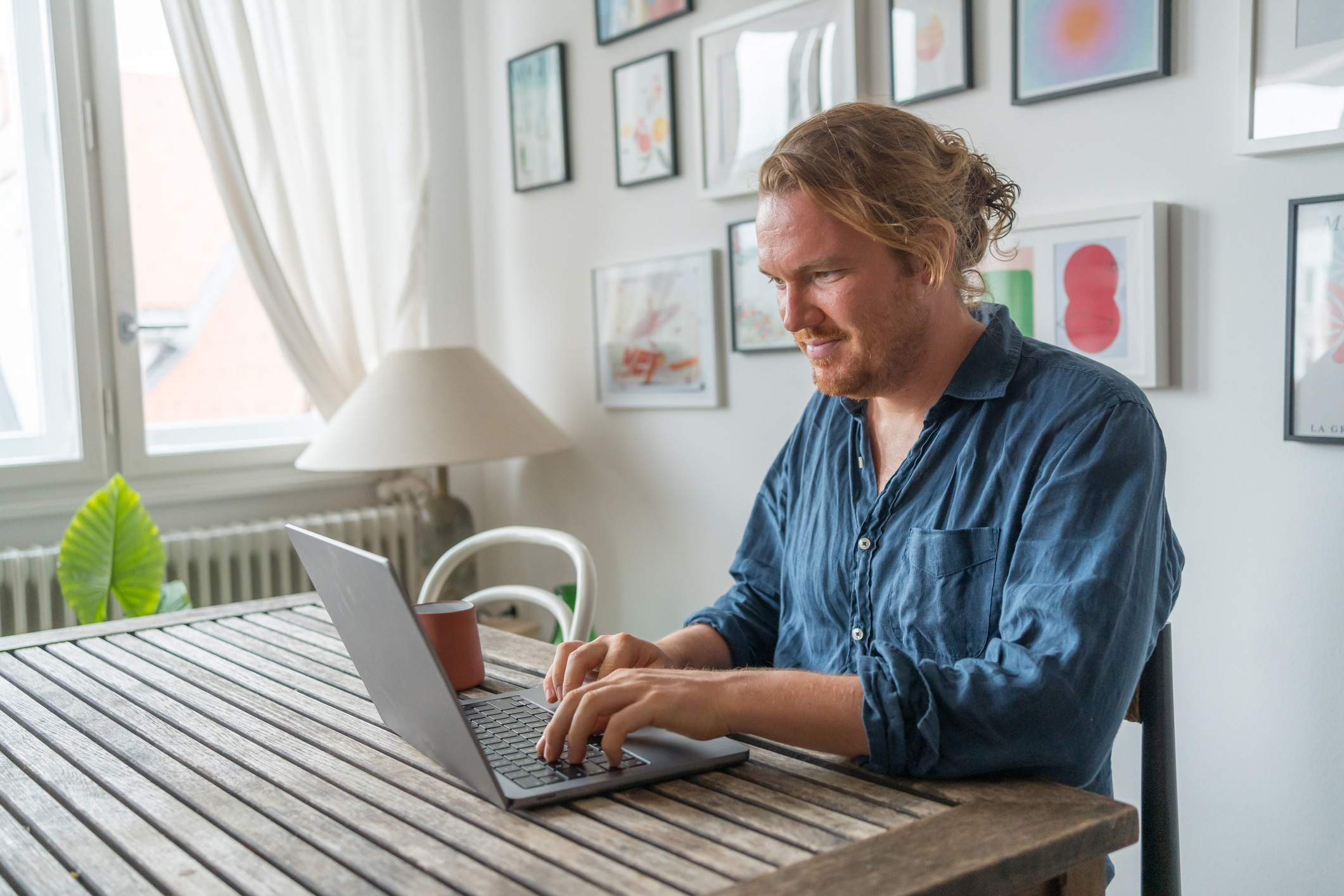 Man works on laptop at dining room table