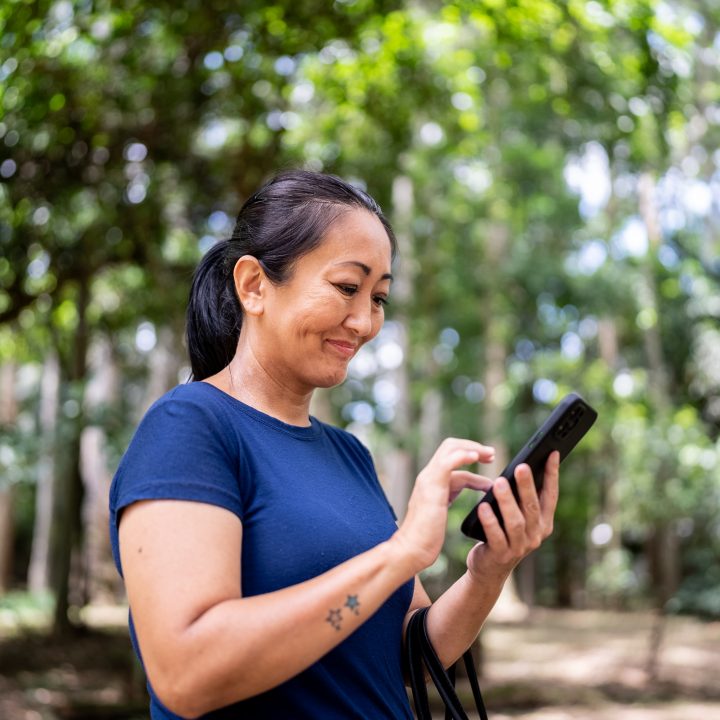 Mature woman using mobile phone on the public park