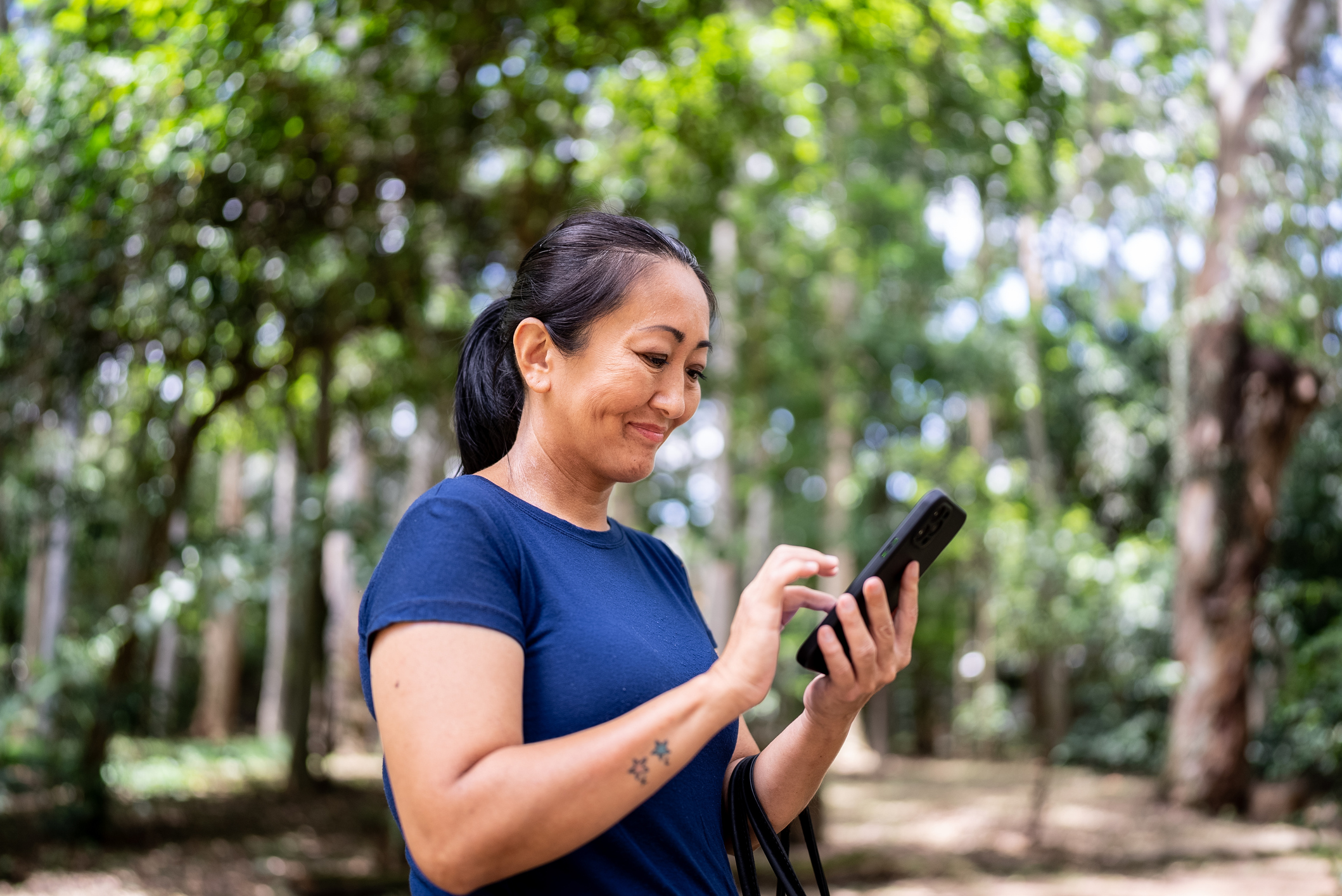 Mature woman using mobile phone on the public park