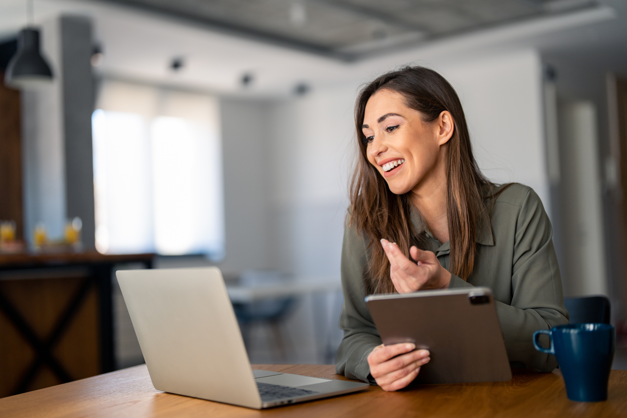 Happy confident businesswoman video calling on laptop, working from home