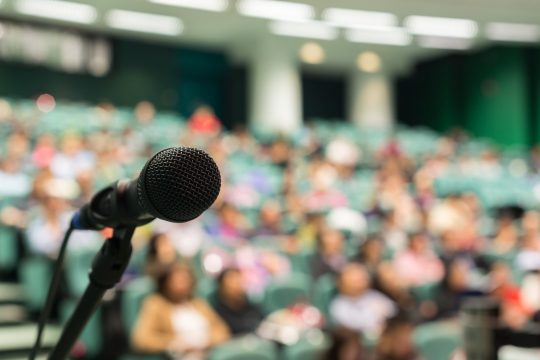 Mircrophone image in front of a audience group