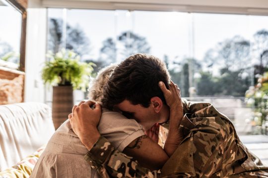 Army soldier embracing his grandmother at home