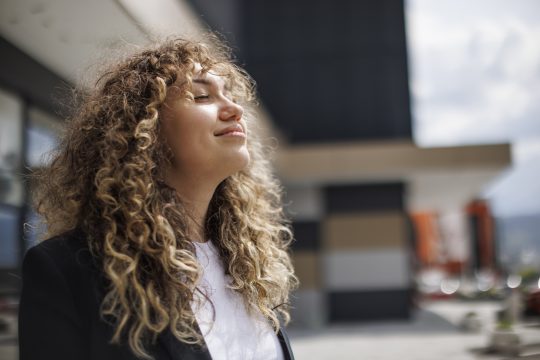 Businesswoman smiling looking up relaxing outdoor