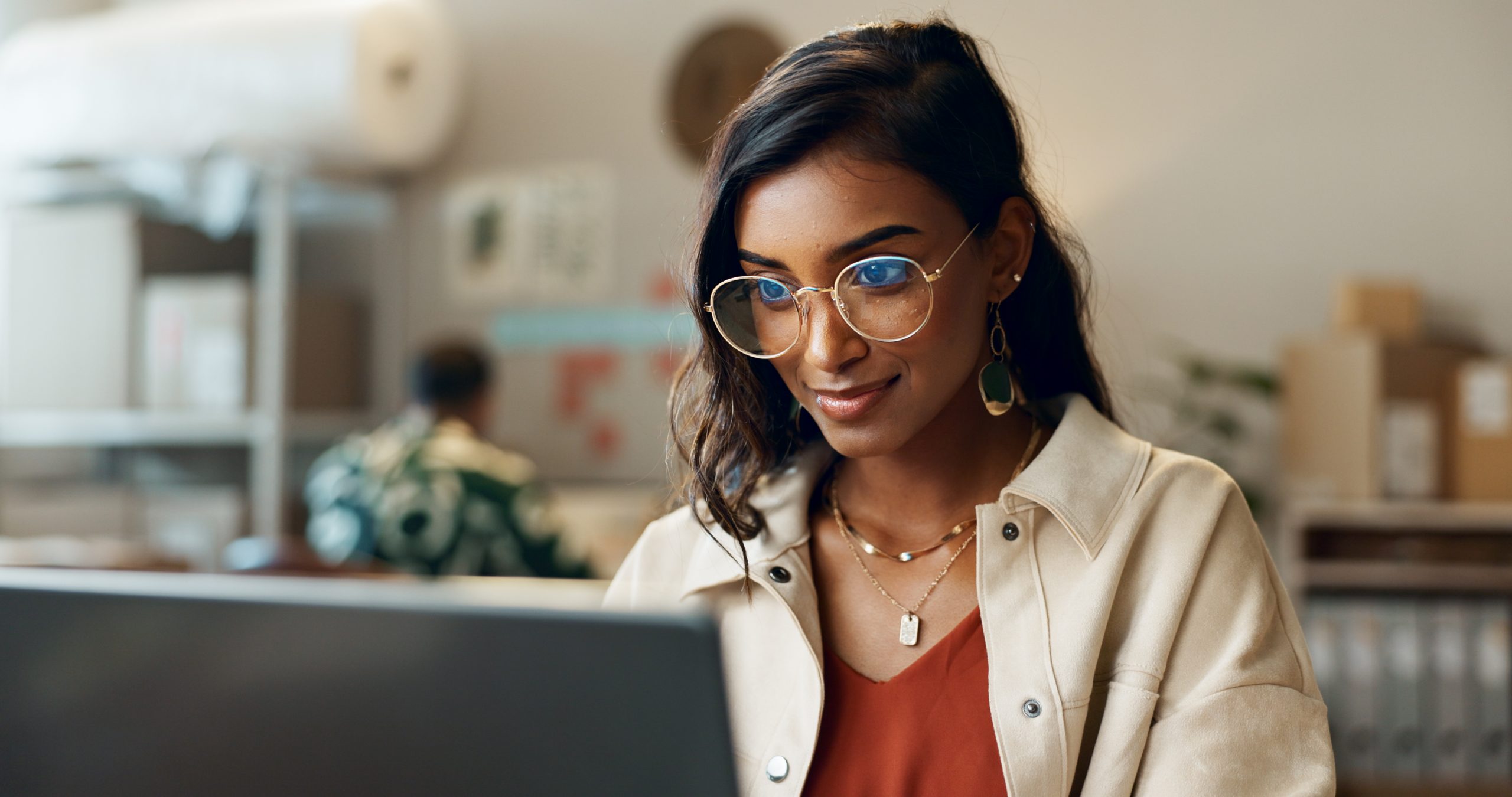 Woman reading on laptop at work for research
