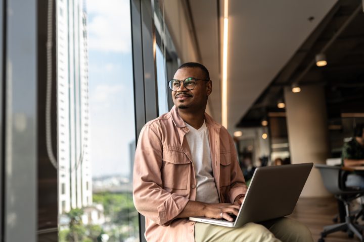 Businessman looking outside window contemplating on the office