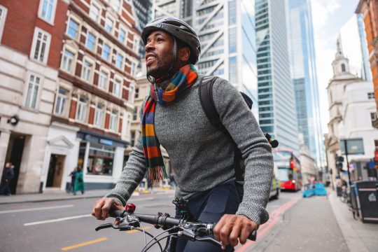 Adult Black Male Smiling While Cycling In The City After Work