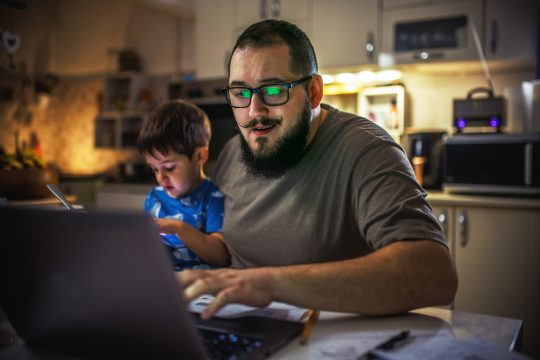 Young dad using laptop checking bills and frustrated with financial problems