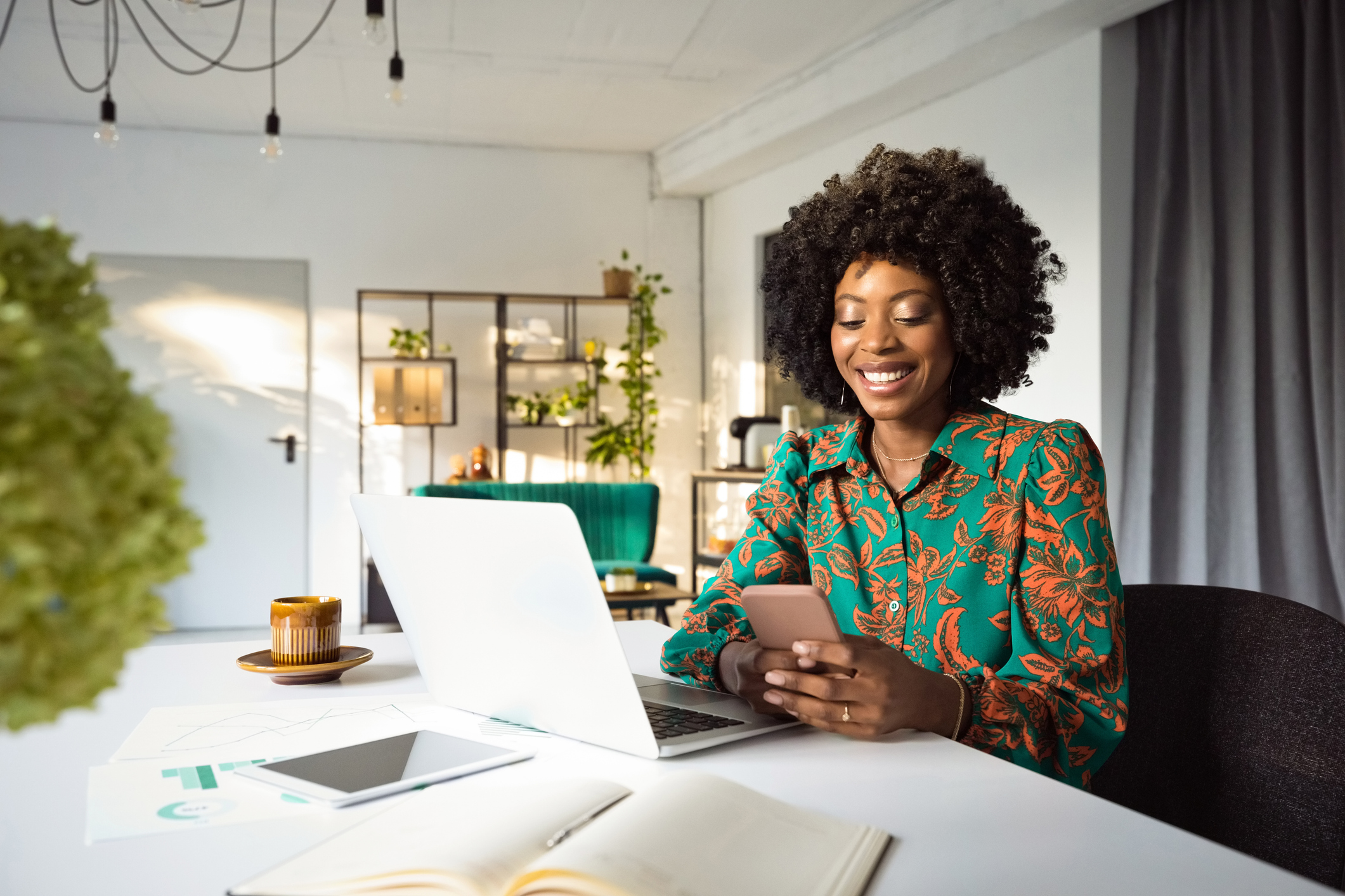 lady smiling using her smartphone and laptop