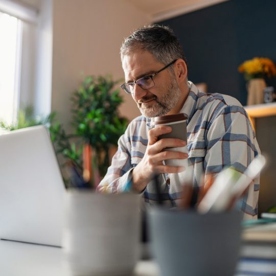 man drinking coffee while working from home