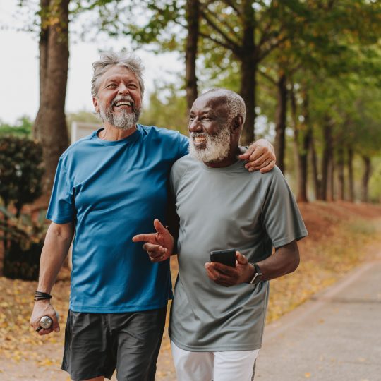 Two senior friends running in the public park