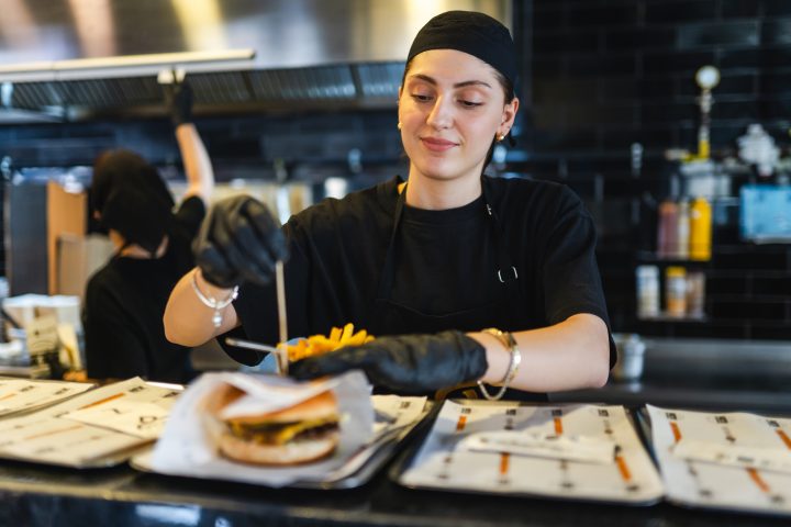 Young woman's first day working at a burger restaurant