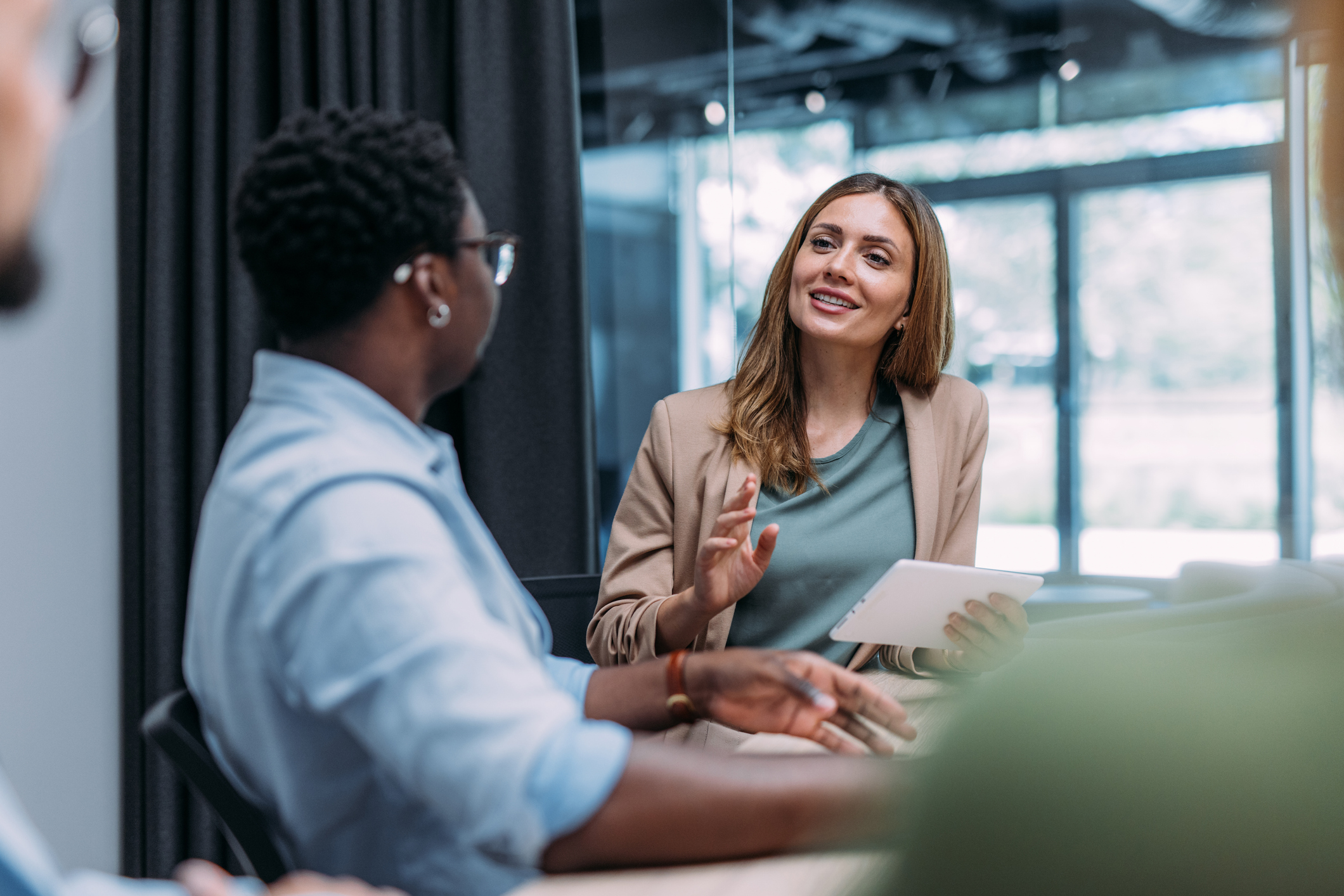 Woman smiling looking at two colleagues in a business meeting