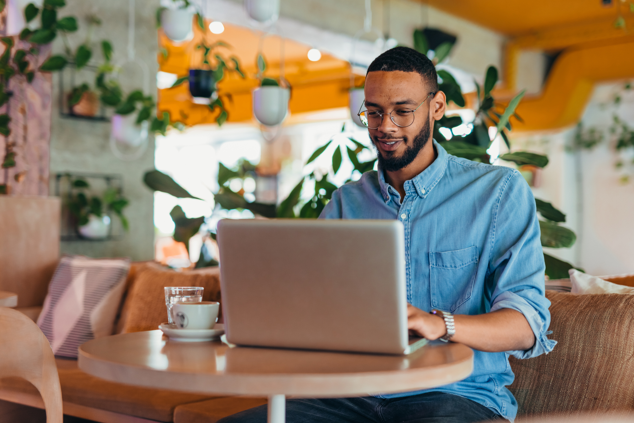 Young man sitting in coffee shop and using laptop