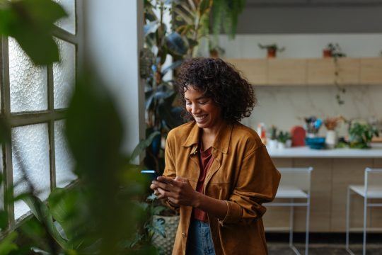 Happy young woman using her smartphone