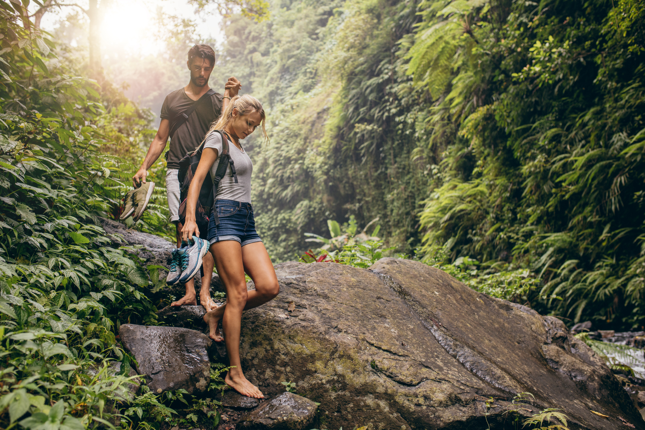 Shot of young couple man and woman walking through the mountain trail