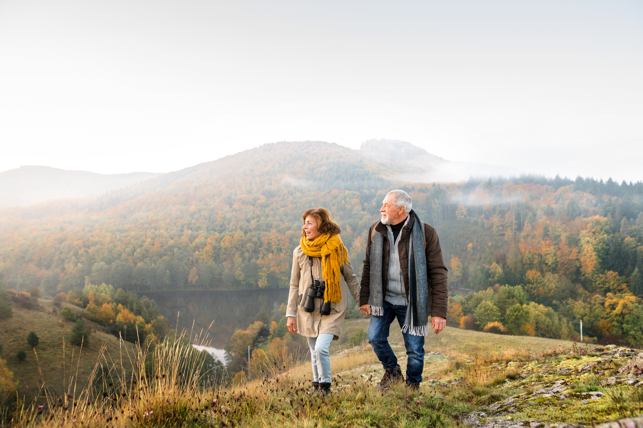 Active senior couple on a walk in a beautiful autumn nature
