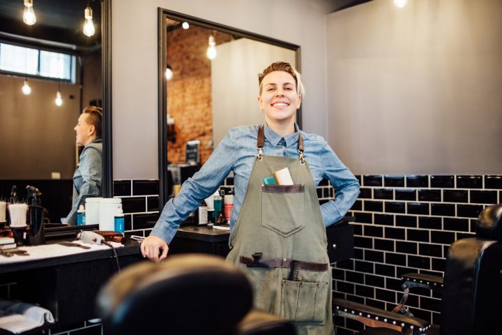 Portrait of female barber smiling in hair salon