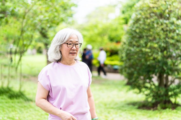 An elderly Asian woman is playing in the park