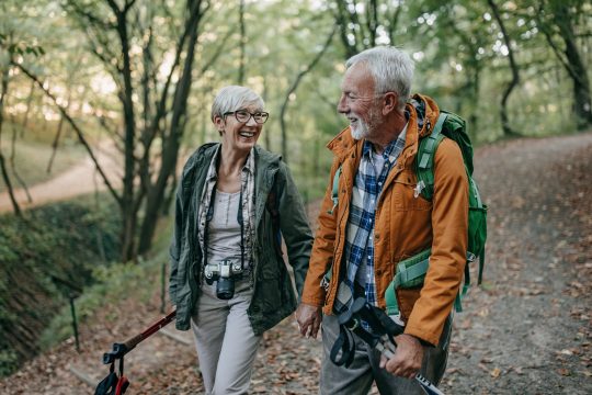 Smiling mature man and women hiking together