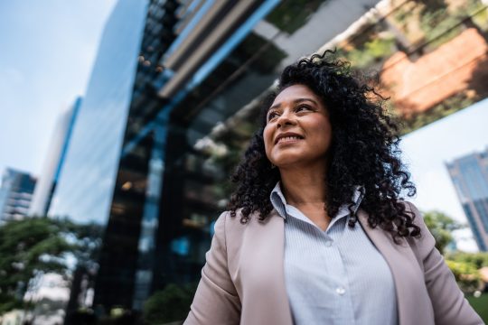 Brown woman wearing business attire looking off camera