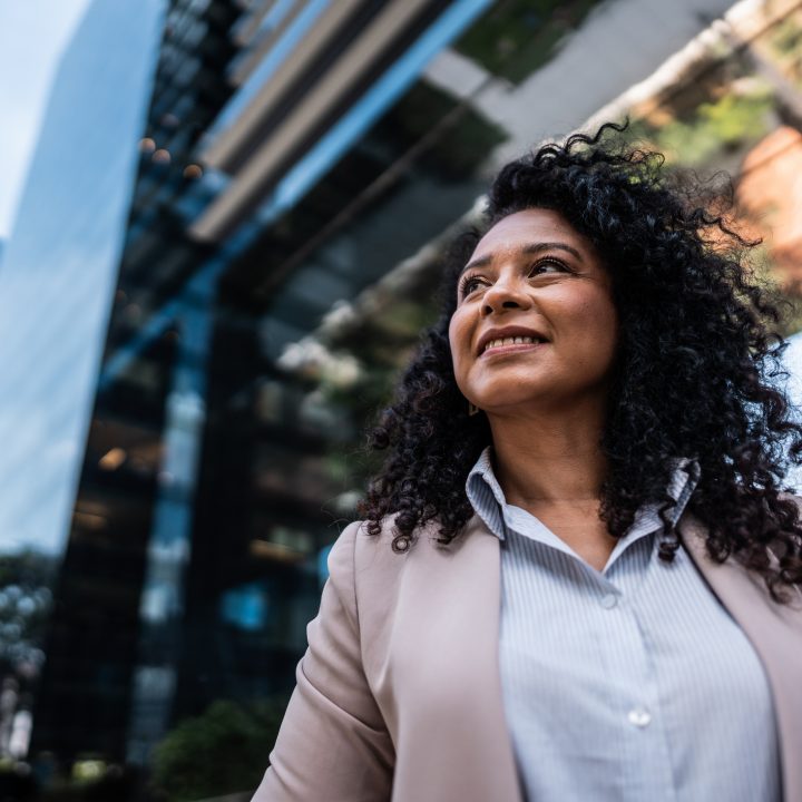 Brown woman wearing business attire looking off camera