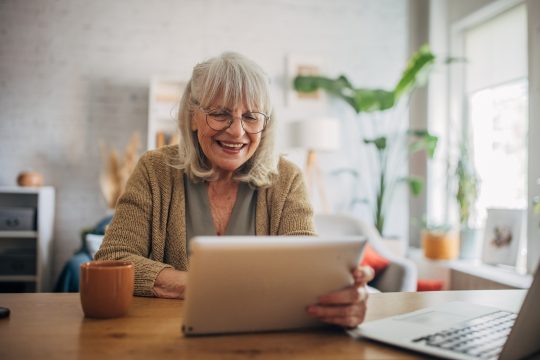 Senior white woman using a digital tablet and talking on video call