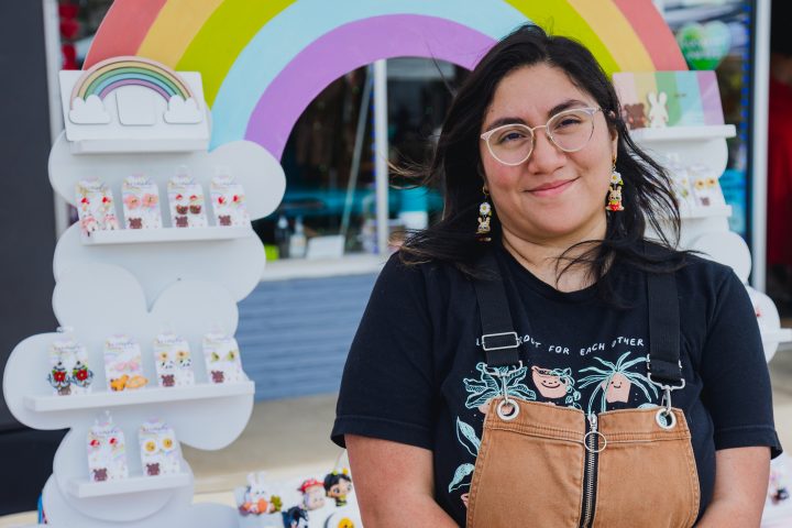proud queer Latina woman standing in front of her small business shop