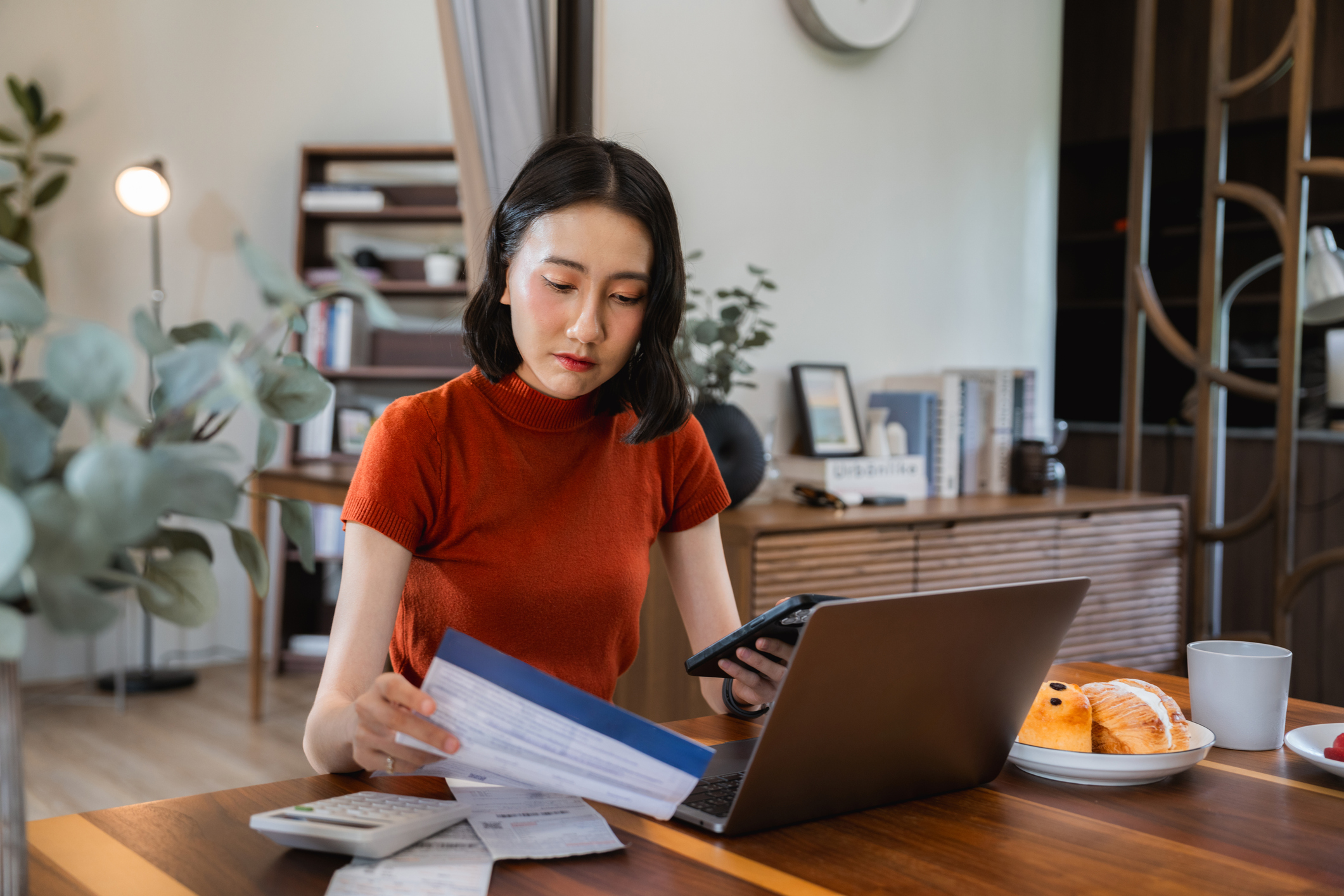 Woman doing personal finances on laptop, making invoices, calculating business expenses