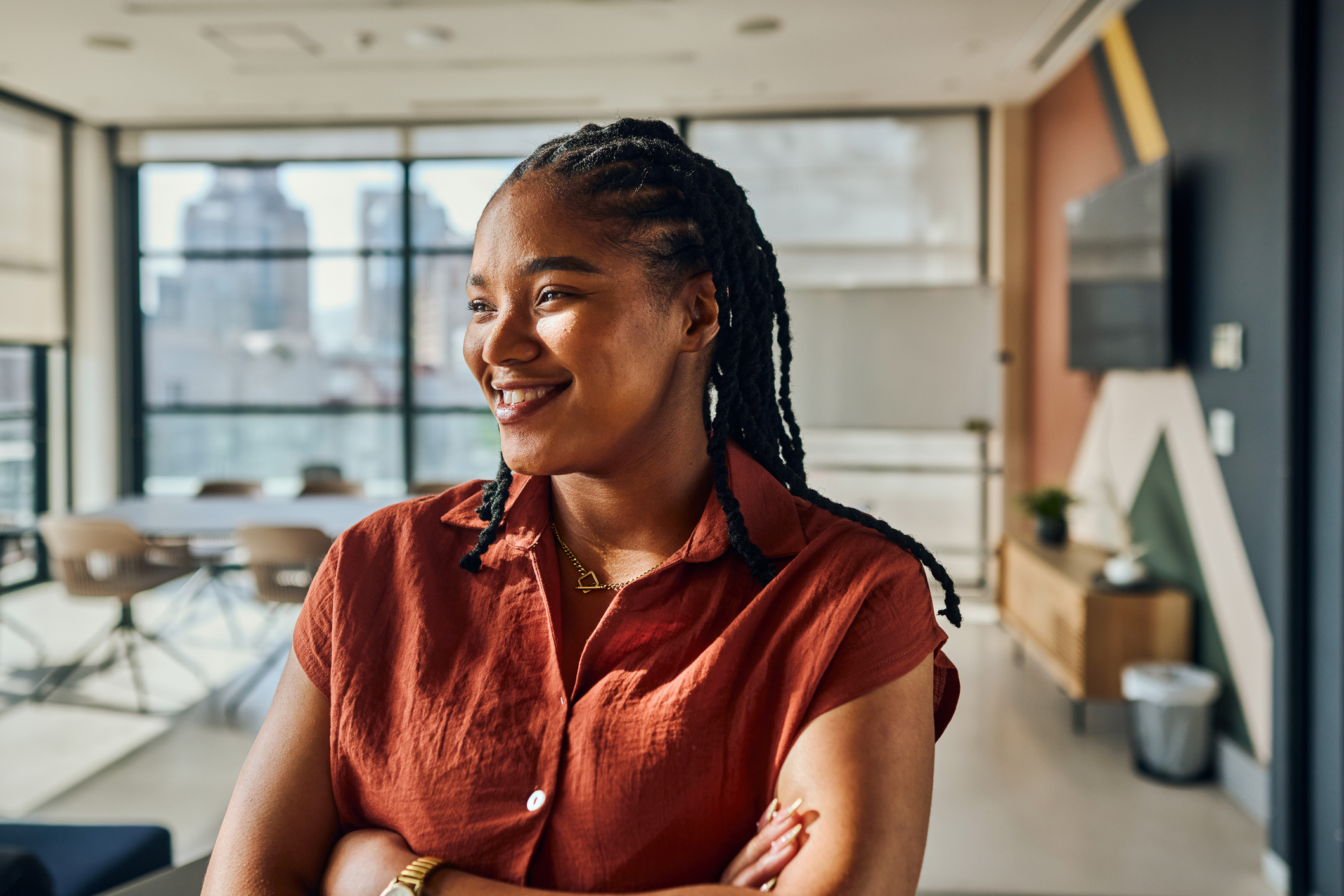 Portrait of a young black female software engineer smiling with crossed arms,