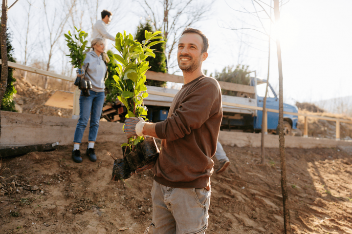 Man planting trees with friends