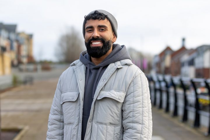 image of man wearing grey jacket smiling