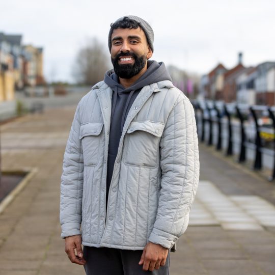 image of man wearing grey jacket smiling