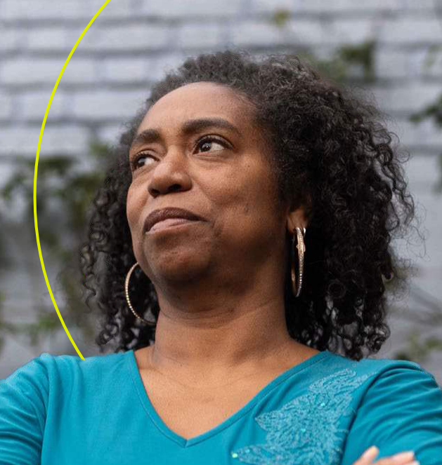 Woman wearing blue top looks serious.