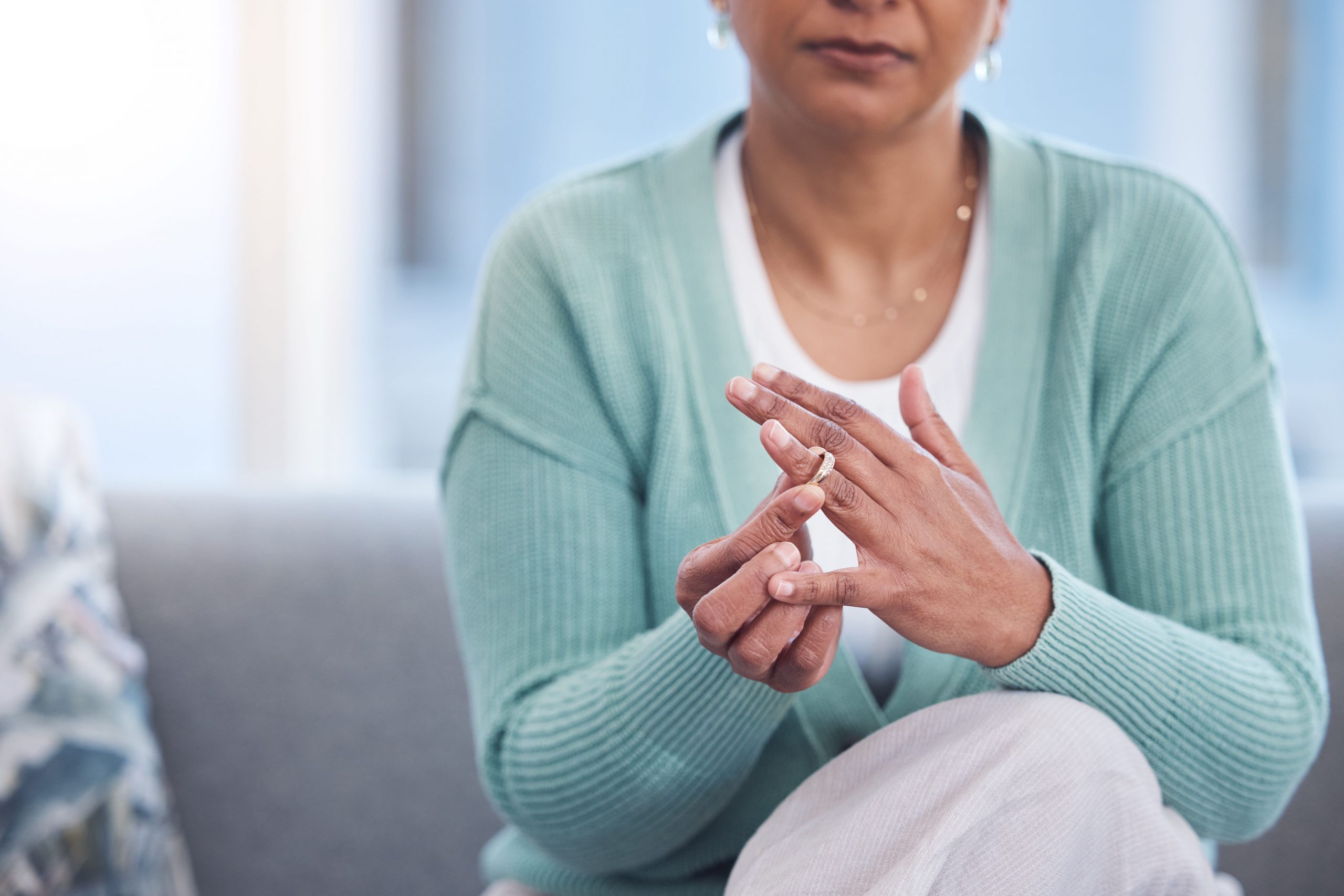 Sad woman removing her wedding ring after divorce
